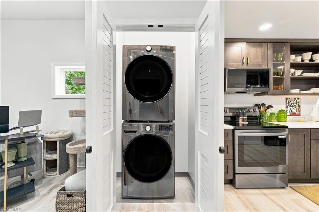 1450 Old Coach Road Kernersville NC accessory dwelling unit interior — stacked LG washer and dryer laundry closet next to the ADU designer kitchen with dark cabinetry and stainless range